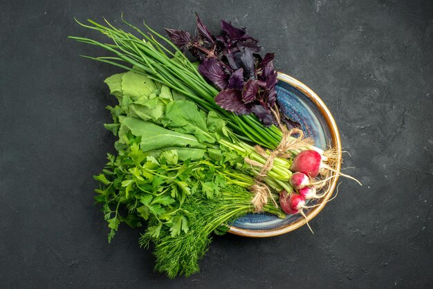Vista superior de verduras frescas con rábano sobre fondo oscuro