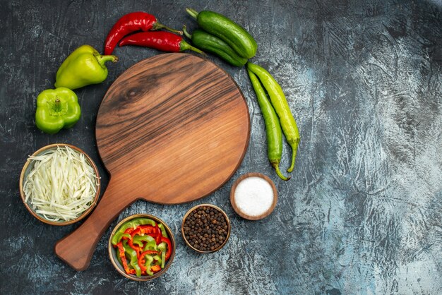 Foto gratuita vista superior de verduras frescas con repollo en rodajas y condimentos sobre el fondo gris claro