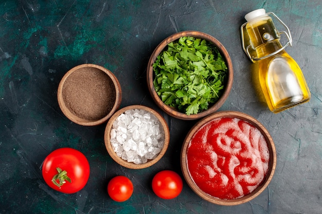 Foto gratuita vista superior de verduras frescas con salsa de tomate y aceite de oliva en la comida de producto de ingrediente de superficie azul oscuro