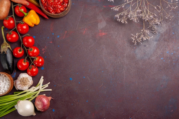 Vista superior de verduras frescas tomates cebollas y patatas en el espacio oscuro