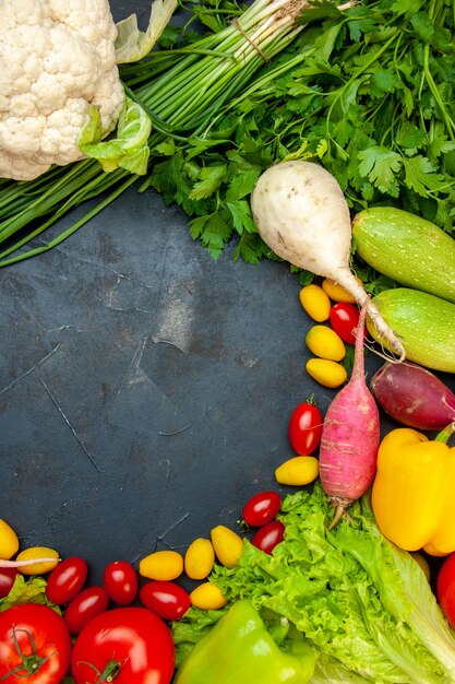 Vista superior de verduras frescas tomates cherry cumcuat coliflor rábano cebolla verde perejil calabacín con espacio libre