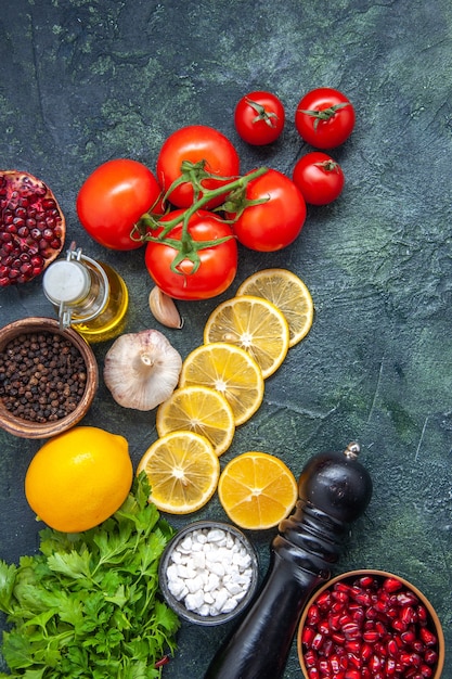 Vista superior de verduras frescas tomates rodajas de limón sal marina en un tazón pequeño molinillo de pimienta en la mesa de la cocina