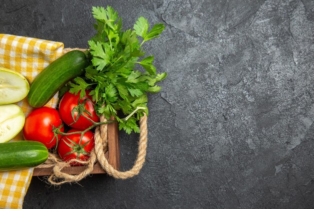 Vista superior de verduras frescas tomates rojos pepinos y calabazas con verduras en la superficie gris