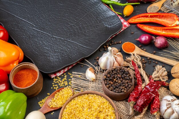 Vista superior de verduras frescas trigo bulgur en tazón de fuente especias ajo negro plato sobre mesa