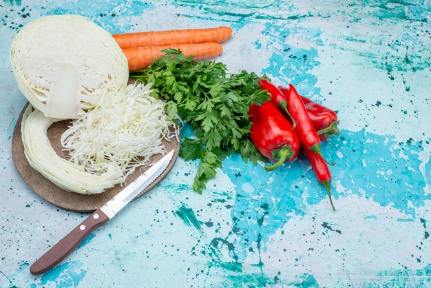 Vista superior de verduras frescas verdes en rodajas repollo zanahorias y pimientos en azul brillante, comida comida almuerzo vegetal ensalada saludable