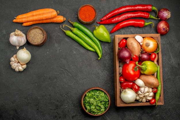 Vista superior de verduras frescas con verduras y ajo en la mesa oscura salud de color de ensalada madura