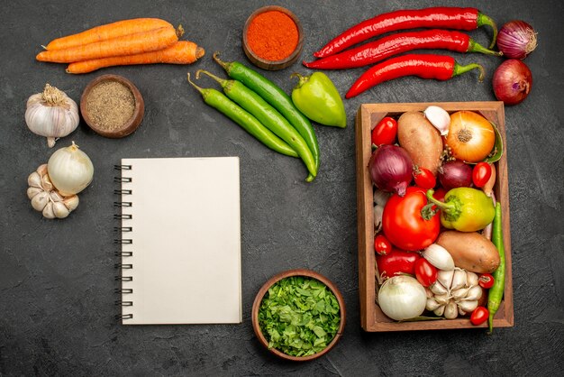 Vista superior de verduras frescas con verduras y ajo en la salud de color de ensalada madura de escritorio oscuro