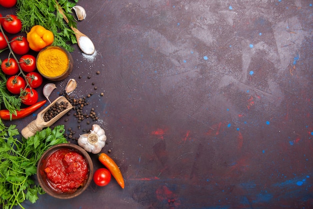 Vista superior de verduras frescas con verduras y condimentos en el espacio oscuro