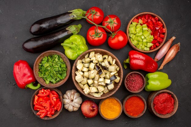 Vista superior de verduras frescas con verduras y diferentes condimentos en la pared gris ensalada de comida saludable comida vegetal