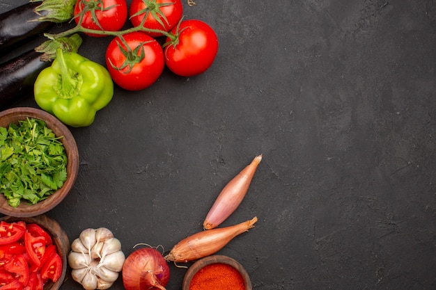 Vista superior de verduras frescas con verduras y diferentes condimentos sobre fondo gris oscuro ensalada de comida comida sana vegetal