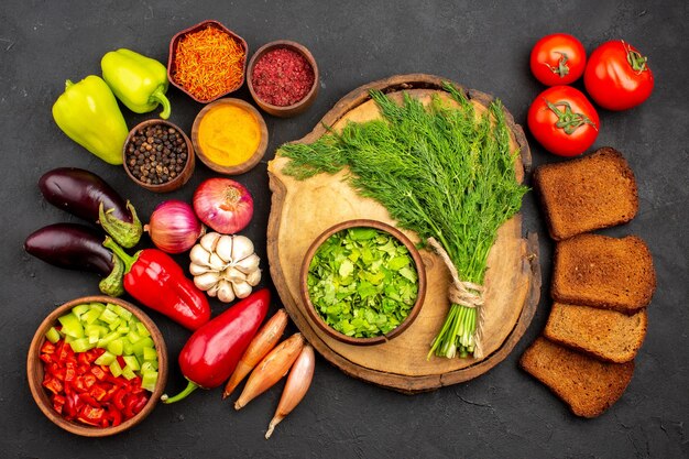 Vista superior de verduras frescas con verduras y hogazas de pan oscuro en el escritorio oscuro, ensalada de pan, comida saludable