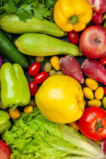 Vista superior de verduras y frutas calabacín pimientos tomates cherry cumcuat manzana membrillo lechuga pepino