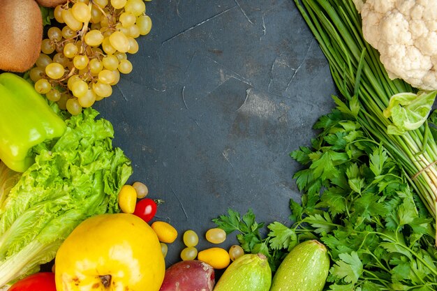 Vista superior de verduras y frutas, lechuga, calabacín, pimientos, membrillo, kiwi, uvas, perejil, cebolla verde, coliflor, espacio libre