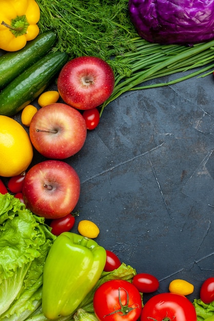 Vista superior de verduras y frutas, tomates cherry, manzanas cumcuat, pepinos, repollo rojo, pimiento, espacio libre