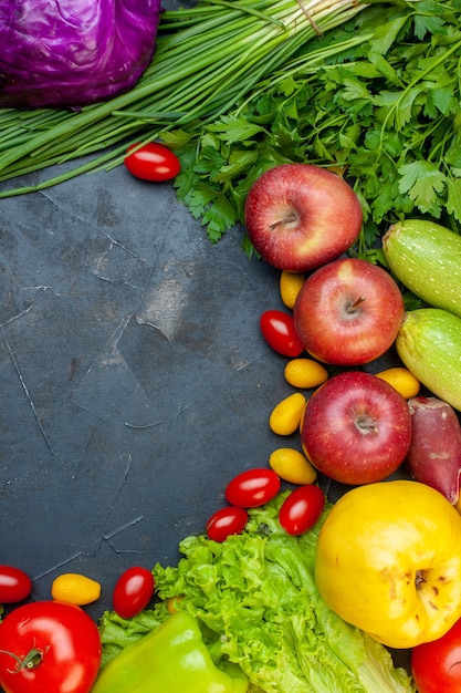 Foto gratuita vista superior de verduras y frutas tomates cherry manzanas cumcuat repollo morado cebolla verde lechuga perejil con espacio libre