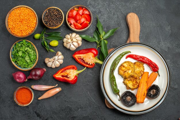 Vista superior de verduras lentejas especias tomates pimiento plato de plato en la tabla de cortar