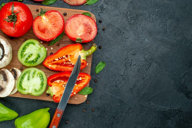 Foto gratuita vista superior de verduras pepinos tomates verdes pimientos en tabla de cortar