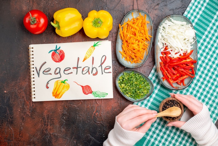 Foto gratuito vista superior de verduras en rodajas, zanahoria, repollo y pimiento con verduras en la mesa oscura