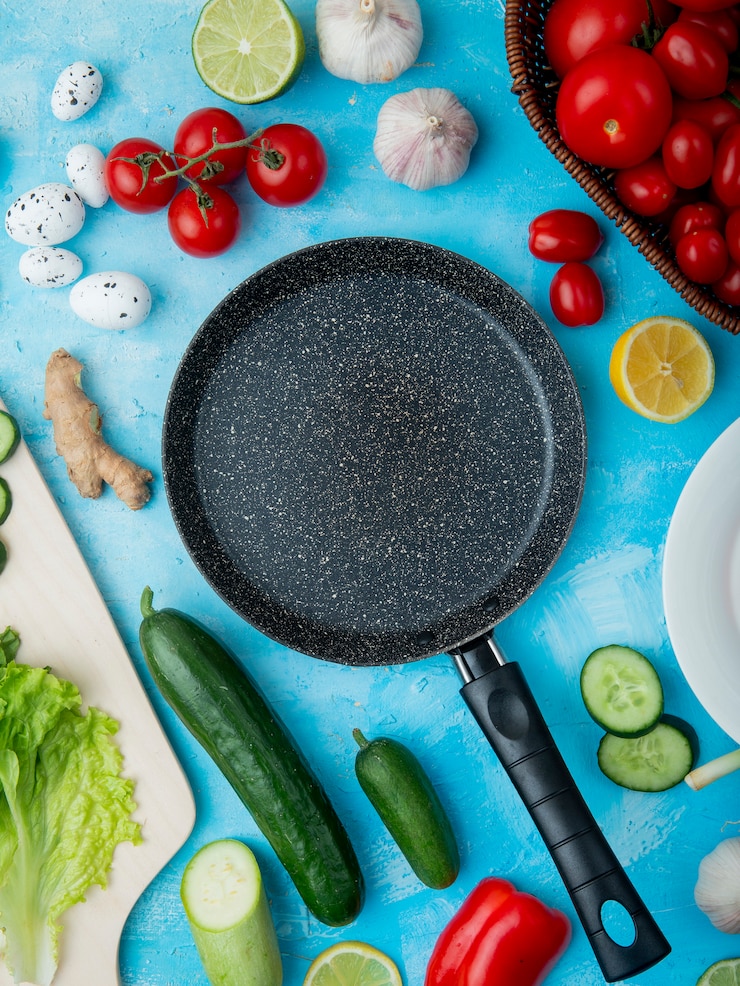 Foto gratuito vista superior de verduras y sartén sobre superficie azul