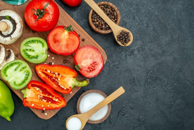 Vista superior de verduras setas tomates pimientos rojos sobre tabla de cortar