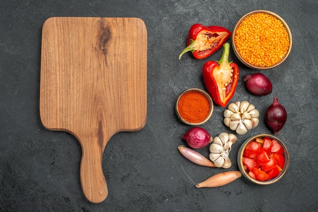 Foto gratuita vista superior de verduras tabla de cortar de madera pimientos cebolla tomates especias ajo