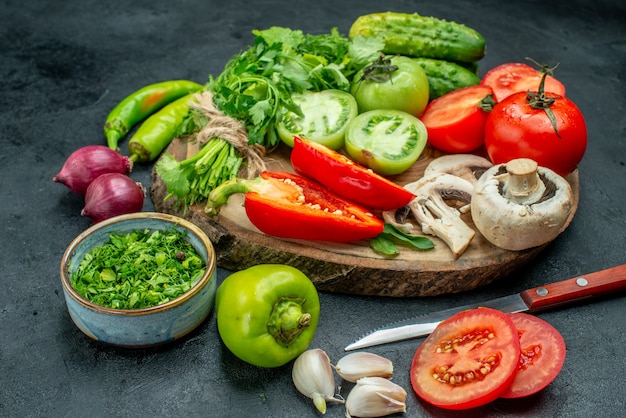 Vista superior de verduras tomates pimientos pepino verdes setas en tablero de madera
