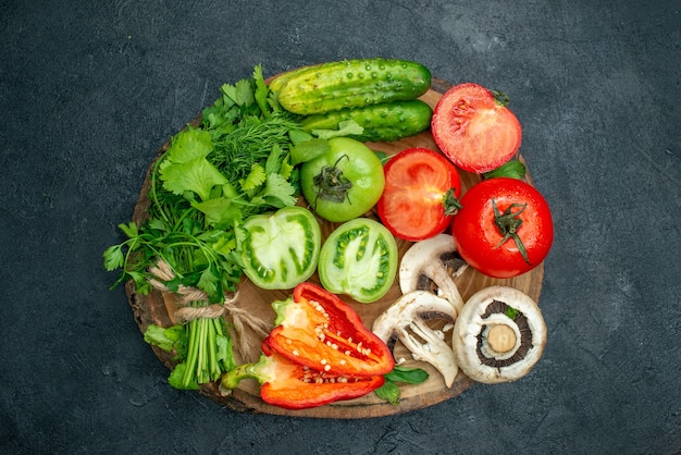 Vista superior de verduras tomates pimientos pepino verdes setas en tablero de madera