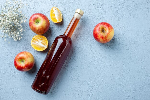 Vista superior de vinagre de manzana en botella sobre fondo blanco jugo de fruta foto en color bebida fresca comida amarga
