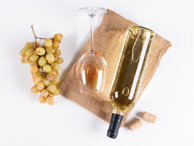 Foto gratuita vista superior de vino blanco en botella y vidrio con uva en bolsa de lino en blanco horizontal