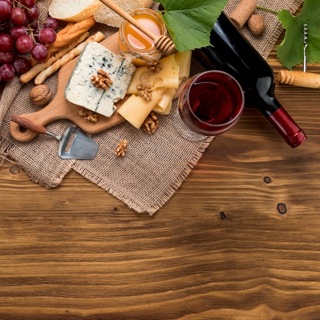 Vista superior vino con comida y racimos de uva