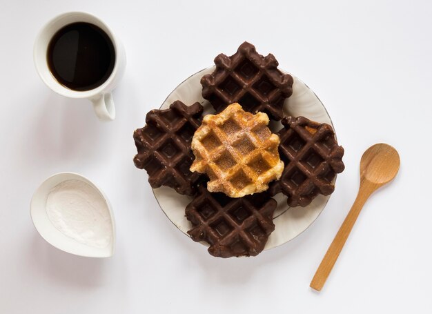 Vista superior de waffles en plato con café y cuchara