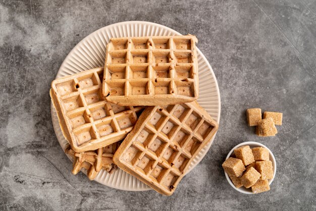 Vista superior de waffles en plato con terrones de azúcar