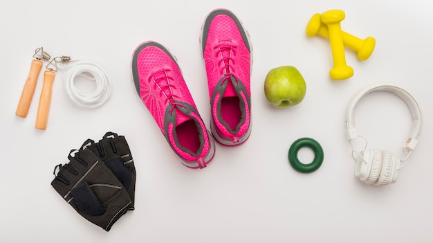 Vista superior de zapatillas con guantes de gimnasia y auriculares