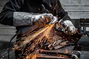 Foto gratuita vista del trabajador moliendo una pieza de metal