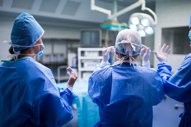 Vista trasera de los cirujanos prepara para la operación en la sala de operación