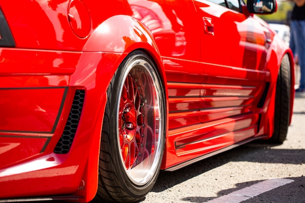 Vista trasera del coche sintonizado deportivo rojo de la rueda