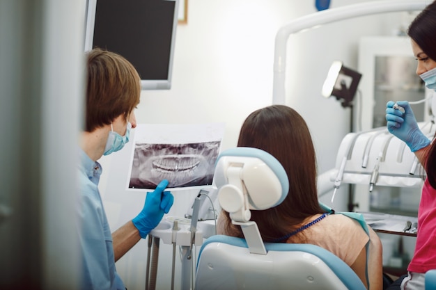 Vista trasera de dentista revisando una radiografía