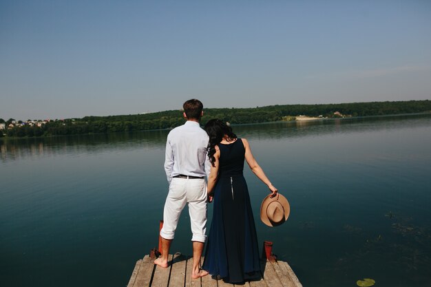 Vista trasera de enamorados contemplando el lago