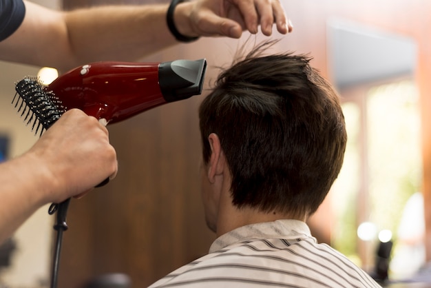 Vista trasera hombre cortándose el pelo