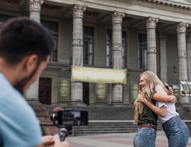 Foto gratuita vista trasera del hombre fotografiando mujeres