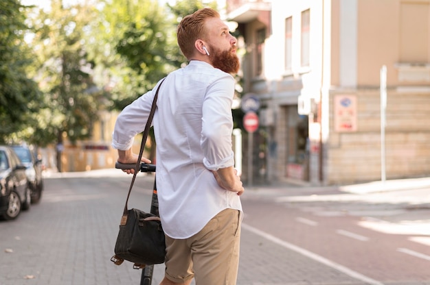 Vista trasera del hombre moderno en scooter al aire libre