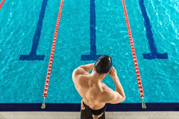 Vista trasera de un hombre preparando gafas de natación