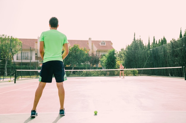 Vista trasera de jugador de tenis en pista