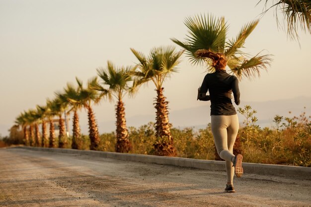 Vista trasera de una mujer atlética determinada corriendo al aire libre