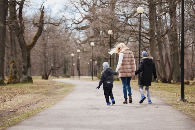 Vista trasera de mujer caminando con sus hijos