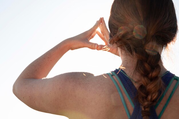 Foto gratuita vista trasera, de, mujer joven, meditar, aire libre