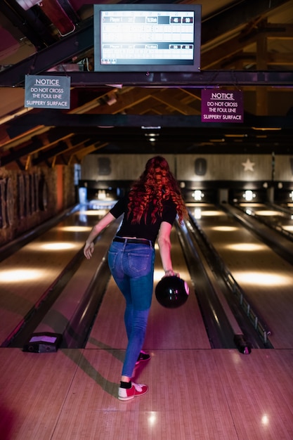 Vista trasera, de, mujer, jugar bolos