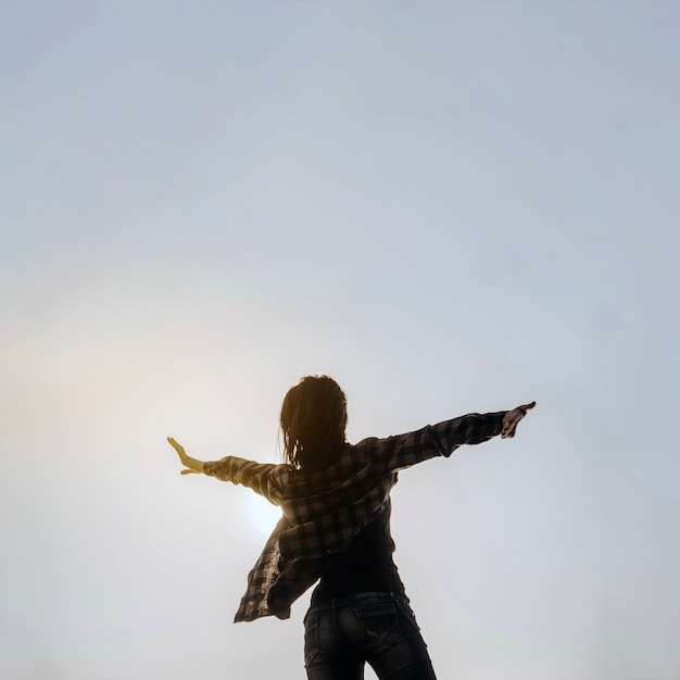 Foto gratuita vista trasera de mujer mirando al cielo