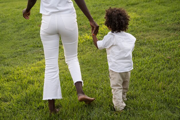 Vista trasera mujer y niño cogidos de la mano