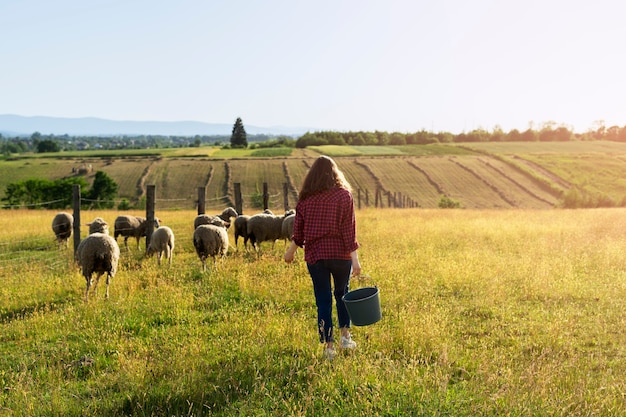 Vista trasera mujer pastora en campo